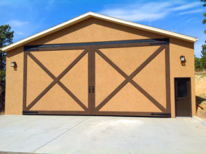 Tan and brown garage, hydraulic door closed, driveway